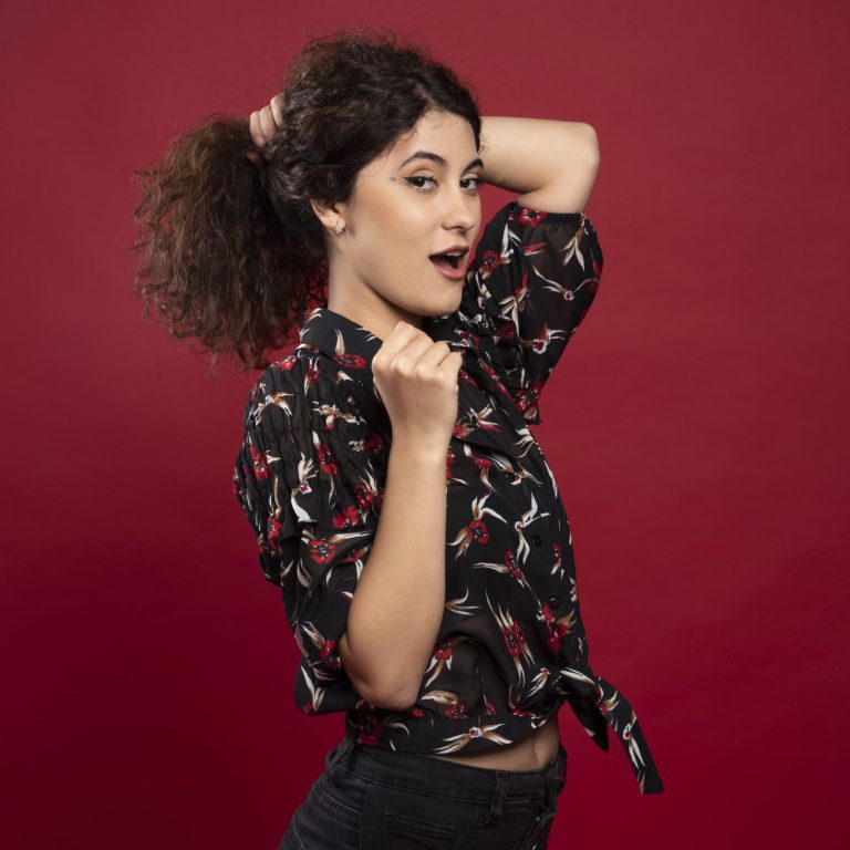 Beautiful curly woman holding her hair like ponytail. High quality photo